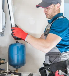 technician-installing-blue-thermal-expansion-tank